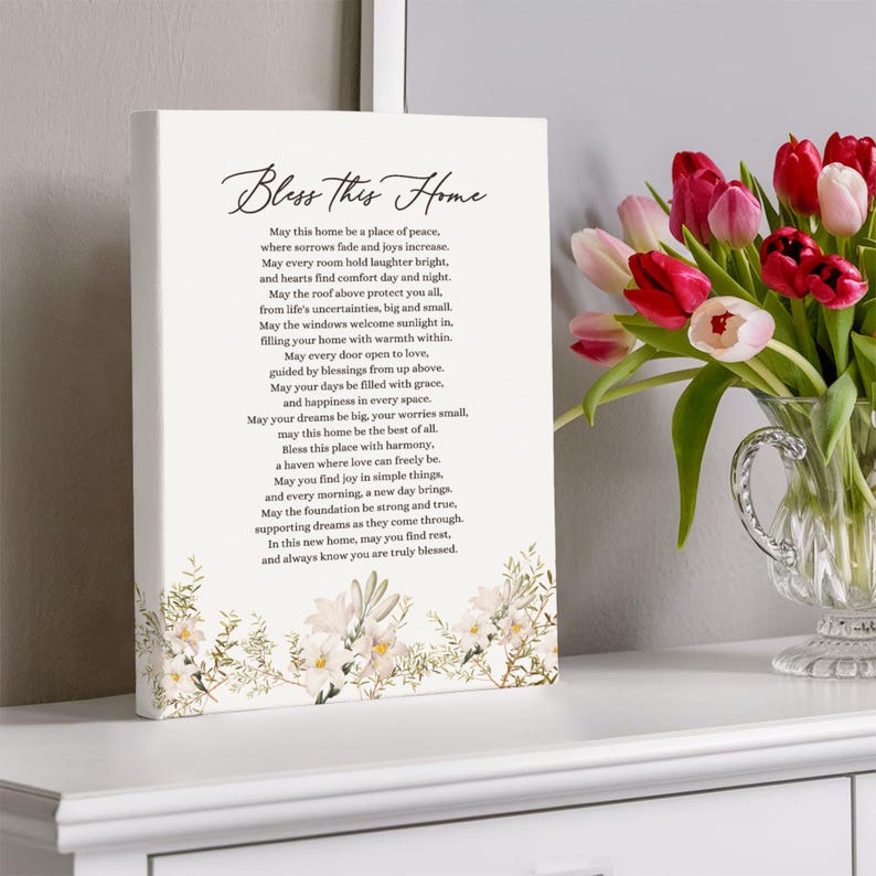 Puede incluir: Una impresi&oacute;n en lienzo blanco con un dise&ntilde;o floral y un poema sobre el hogar. El poema dice "Bless this Home" e incluye frases como "un lugar de paz", "risas brillantes" y "un refugio donde el amor puede ser libre".