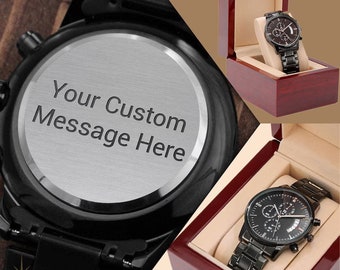 May include: Black chronograph wristwatch with a black stainless steel band and a date window. The watch comes in a wooden box with a silver back that can be engraved with a custom message. "Your Custom Message Here" is engraved on the back of the watch.