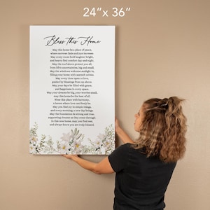 Puede incluir: Una impresi&oacute;n en lienzo de 61 cm x 91 cm con un dise&ntilde;o floral y un poema titulado "Bless This Home". El poema trata sobre encontrar la paz, la alegr&iacute;a y el amor en un hogar.