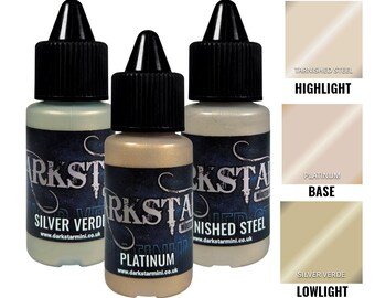 May include: Three bottles of Darkstar Modern Metallic paint in Silver Verdi, Platinum, and Tarnished Steel. Each bottle has a black cap and a label with the brand name and product name. Color swatches for each paint are shown on the right.