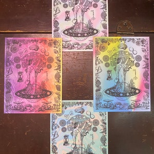 May include: Four psychedelic prints with a rainbow gradient background. Each print features a black and white illustration of a tree with a woman standing in it. The woman is holding a book and a key. The text "DEATHMOODIVERSITY" is written on a banner above the tree. The tree is surrounded by mushrooms and other plants. The prints are all the same design, but each has a different color gradient.