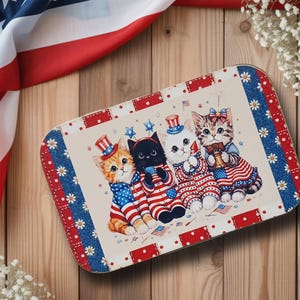 May include: Rectangular metal tray featuring four cartoon kittens dressed in patriotic attire. The kittens wear red, white, and blue outfits and hats, with American flags and stars. The tray has a red, white, and blue border with floral and polka dot patterns.