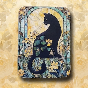 May include: A rectangular decorative piece featuring a black cat in a stained-glass window design. The cat is silhouetted against a sunburst, surrounded by yellow and blue floral elements. The background has a floral pattern.