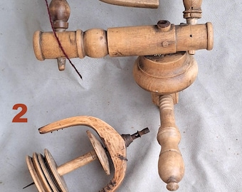May include: Three antique wooden spinning wheels with a spindle and a whorl. The wheels are made of light brown wood and have a natural finish. The wheels are numbered 1, 2, and 3.