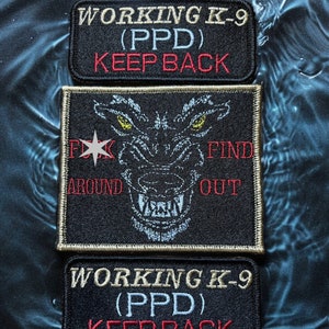 May include: Three embroidered patches with text and a wolf design. The top and bottom patches read "WORKING K-9 (PPD) KEEP BACK" in tan and red. The center patch features a wolf face and the text "F**k Around Find Out".