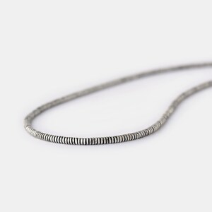 May include: A silver chain necklace made of small, round beads.
