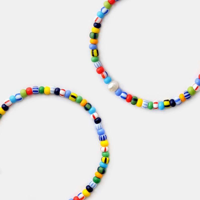 Mens multicolor beaded bracelet made with 4mm rainbow color beads and genuine pearls that are strung on a stretch string that easily slips on your wrist for easy everyday wear.