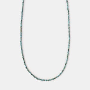 May include: A turquoise beaded necklace with a delicate design. The necklace is made of small, round beads that are strung together on a thin cord.
