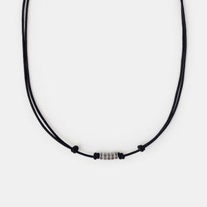May include: A black cord necklace with a silver bead pendant. The bead is made up of several stacked rings.