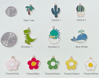 May include: Assortment of colourful enamel pet collar charms, including a palm tree, cactus, dinosaur, whale, and flowers in pink, red, green, yellow, and white.
