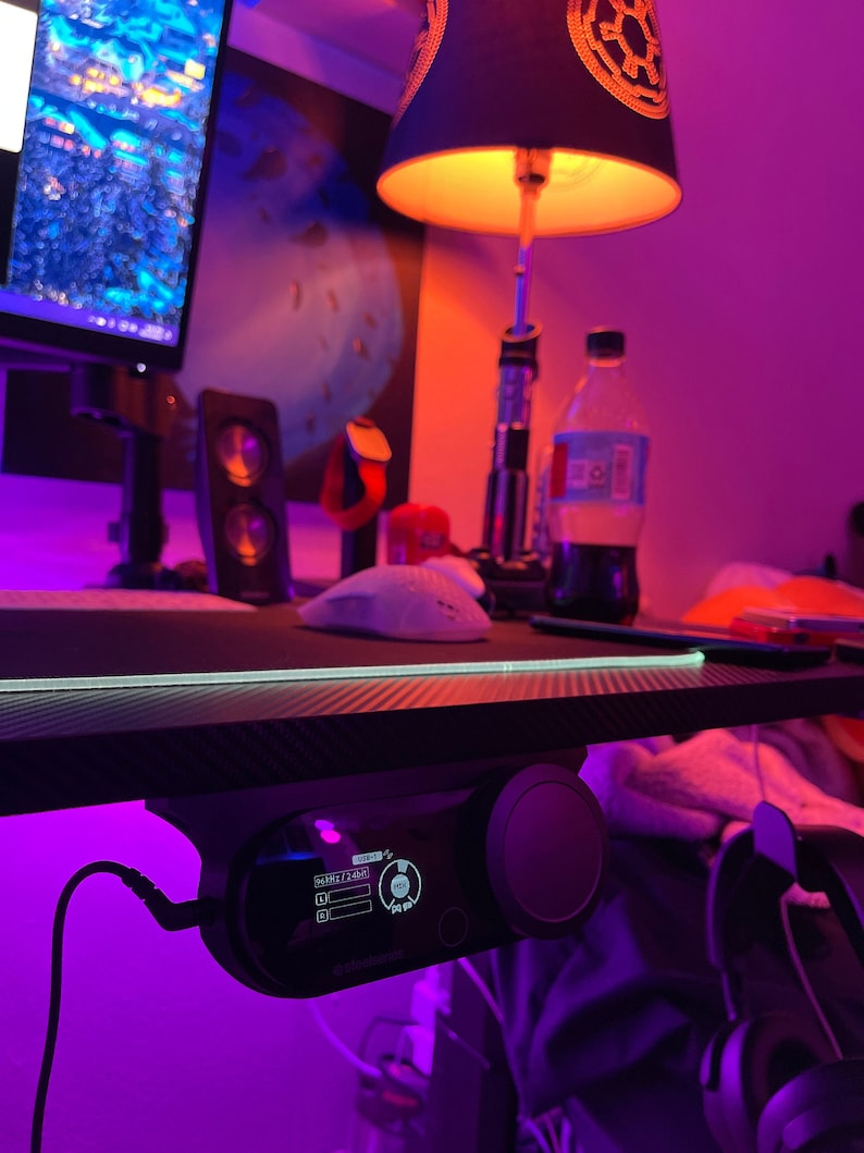 May include: A black desk with a purple light strip and a black and silver desk controller with a screen that reads "SHARE 1/2/3/4" and "HIGH".