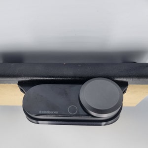 May include: A black SteelSeries gaming headset with a round, black volume control knob.