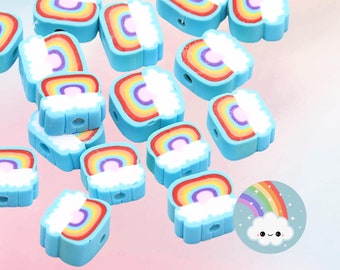 Könnte beinhalten: Eine Sammlung von 16 blauen und regenbogenfarbenen Tonperlen in Form eines Regenbogens mit einer Wolke oben. Die Perlen haben ein Loch in der Mitte zum Auf fädeln.