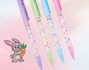 May include: Four mechanical pencils with cute rabbit designs. The pencils are pink, blue, green, and purple. Each pencil has a plaid pattern and a white rabbit with the text "Cute Rabbit" on the barrel.