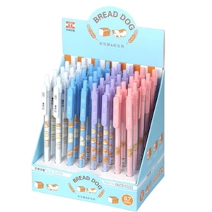 May include: A display of 40 pink, blue, and white mechanical pencils with a bread and dog design. The pencils are 0.7 mm and are labeled "Bread Dog".