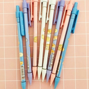 May include: A set of eight mechanical pencils with colorful barrels and cute cartoon animal designs. The pencils have a variety of colors, including blue, pink, purple, and white. The pencils are all sharpened and ready to use.