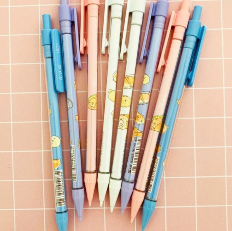 May include: A set of eight mechanical pencils with colorful barrels and cute cartoon animal designs. The pencils have a variety of colors, including blue, pink, purple, and white. The pencils are all sharpened and ready to use.