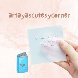 Könnte beinhalten: Ein hellblaues Cartoon-Buch mit einem lächelnden Gesicht und einem Haftzettel mit dem Text "Remember to smile in this messy life every day." Der Text "artayascutesycorner" steht oben.