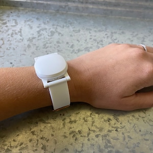 This shows an Ava Fertility Tracker 2.0 attached to the adapter, and worn on the wrist using the optional watch band.