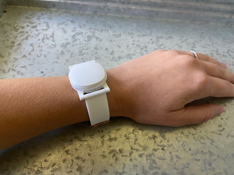 This shows an Ava Fertility Tracker 2.0 attached to the adapter, and worn on the wrist using the optional watch band.