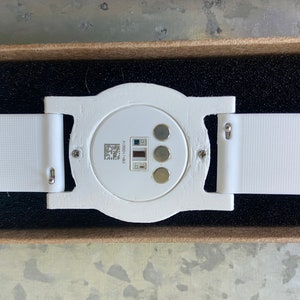 Close-up view of the bottom of the adapter. The Ava Fertility Tracker 2.0 is attached to the adapter with the original screws. The optional 18mm watch band snaps into the lugs of the adapter with spring bars.