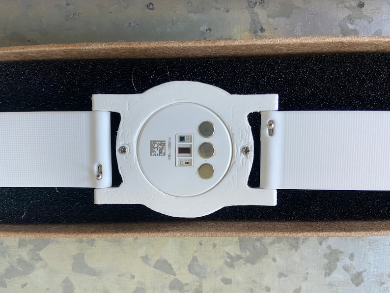 Close-up view of the bottom of the adapter. The Ava Fertility Tracker 2.0 is attached to the adapter with the original screws. The optional 18mm watch band snaps into the lugs of the adapter with spring bars.