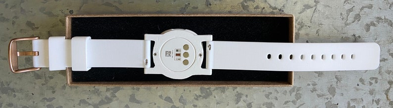 This is the underside of the adapter showing the adapter, the optional watch band, and an attached Ava Fertility Tracker 2.0 (tracker not included in this listing).