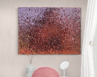 May include: Abstract wall art with a textured, speckled design in shades of red, orange, and purple. The artwork hangs above a vanity table with a pink chair, a vase with flowers, and a white mirror. The table has a gold frame.