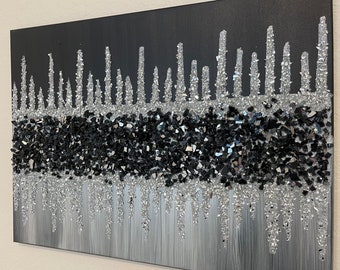 May include: Black and silver abstract art painting with a textured, glittery finish. The painting features a horizontal band of black and silver glitter, with silver glitter dripping down the canvas.