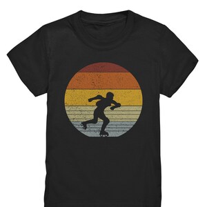 May include: Black t-shirt with a vintage-style graphic of a person roller skating in front of a sunset.