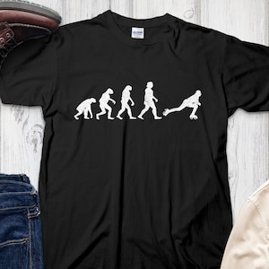 Puede incluir: Camiseta negra con un gráfico blanco de la evolución del hombre, que termina con una persona en patines. El gráfico dice "Evolution of a Rollerblader".