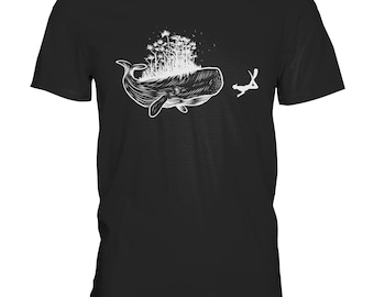 Może przedstawiać: Czarny T-shirt z białym nadrukiem przedstawiającym wieloryba z rosnącym na jego grzbiecie lasem. Nurk pływa przed wielorybem.