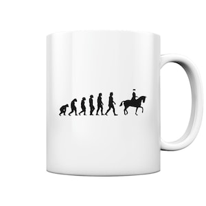 Könnte beinhalten: Weiße Keramiktasse mit einer schwarzen Silhouette, die die menschliche Evolution darstellt und mit einer Person auf einem Pferd endet. Das Design ist auf die Seite der Tasse gedruckt, die einen gebogenen Henkel hat.
