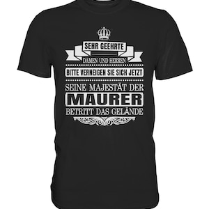 May include: Black t-shirt with white text that reads "Sehr geehrte Damen und Herren, Bitte verneigen Sie sich jetzt. Seine Majestät der Maurer betritt das Gelände."