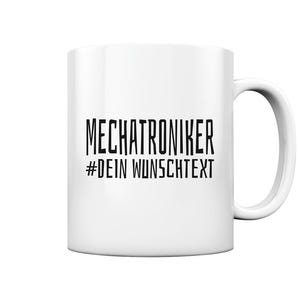 May include: White ceramic mug featuring the text "MECHATRONIKER #DEIN WUNSCHTEXT" in black. The mug has a standard handle and a cylindrical shape, suitable for tea or coffee.