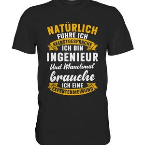 Puede incluir: Camiseta negra con texto amarillo y blanco. El texto dice: "NATÜRLICH FÜHRE ICH SELBSTGESPRÄCHE ICH BIN INGENIEUR Und Manchmal brauche ICH EINE EXPERTENMEINUNG". La camiseta tiene cuello redondo y mangas cortas.