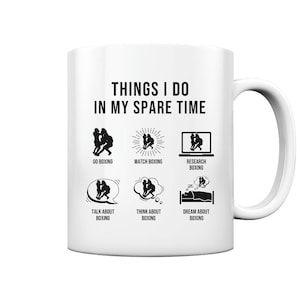 Könnte beinhalten: Eine weiße Kaffeetasse mit einer schwarz-weißen Illustration einer Person, die boxt. Der Text "THINGS I DO IN MY SPARE TIME" befindet sich oben auf der Tasse. Die Illustration zeigt eine Person, die boxt, Boxen schaut, Boxen recherchiert, über Boxen spricht, an Boxen denkt und von Boxen träumt.