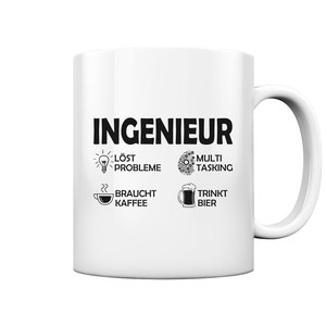 May include: White ceramic coffee mug with black text that reads "INGENIEUR" and four icons. The icons depict a lightbulb with the text "LÖST PROBLEME", a gear with the text "MULTI TASKING", a coffee cup with the text "BRAUCHT KAFFEE", and a beer mug with the text "TRINKT BIER".