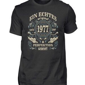 Könnte beinhalten: Ein schwarzes T-Shirt mit einem Vintage-Design mit dem Text "Ein Echtes Original seit 1977 zur Perfektion gereift".