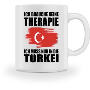 Puede incluir: Taza de cerámica blanca con un diseño en negro y rojo. La taza presenta el texto "Ich brauche keine Therapie Ich muss nur in die Türkei" y una imagen estilizada de la bandera turca.