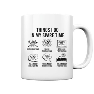 Peut inclure: Une tasse en céramique blanche avec une illustration en noir et blanc d'un crâne portant un casque de pompier et une hache. Le texte "THINGS I DO IN MY SPARE TIME" est en haut de la tasse. Sous le texte, six illustrations du crâne avec différentes activités liées à la lutte contre les incendies, notamment "DO FIREFIGHTING", "WATCH FIREFIGHTING", "RESEARCH FIREFIGHTING", "TALK ABOUT FIREFIGHTING", "THINK ABOUT FIREFIGHTING", et "DREAM ABOUT FIREFIGHTING".