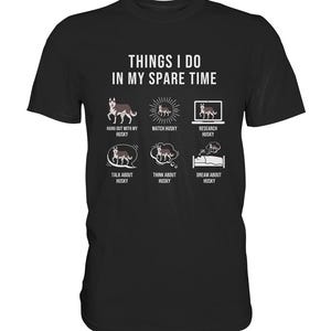 Könnte beinhalten: Ein schwarzes T-Shirt mit weißem Text, der "Things I do in my spare time" lautet. Der Text ist in einem Raster angeordnet, mit sechs Symbolen, die Aktivitäten im Zusammenhang mit Huskys darstellen, wie z. B. mit einem Husky rumhängen, einen Husky beobachten, Huskys recherchieren, über Huskys sprechen, an Huskys denken und von Huskys träumen.