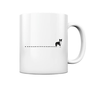 Op de afbeelding: Witte keramische mok met een zwart-wit silhouet van een hond en een stippellijn. De mok heeft een gebogen handvat en een minimalistisch ontwerp. Ideaal voor warme dranken, het ontwerp van de mok is eenvoudig en strak.