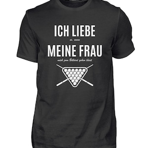 Peut inclure: T-shirt noir avec du texte blanc qui dit "Ich liebe es, wenn meine Frau mich zum Billard gehen lässt." Le texte est entouré d'un graphique d'un billard avec des boules et des queues croisées.
