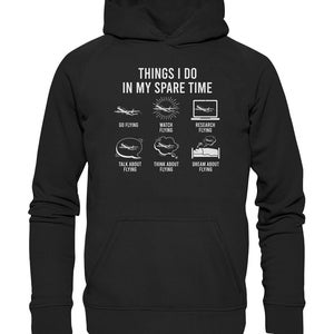 May include: Black hoodie with white text that reads "Things I do in my spare time" and a series of icons depicting airplanes and the words "Go Flying", "Watch Flying", "Research Flying", "Talk About Flying", "Think About Flying", and "Dream About Flying".