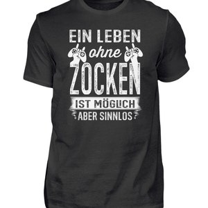 Könnte beinhalten: Schwarzes T-Shirt mit weißem Text: "EIN LEBEN ohne ZOCKEN IST MÖGLICH ABER SINNLOS" und Controller-Grafiken. Das Shirt hat einen Rundhalsausschnitt und kurze Ärmel.