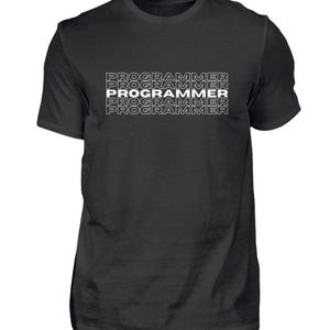Op de afbeelding: Zwart t-shirt met het woord "PROGRAMMER" vier keer wit op elkaar gestapeld, omlijnd met zwart. Het shirt heeft korte mouwen en een ronde hals.