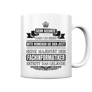 May include: White ceramic mug with a black design that says "Sehr geehrte Damen und Herren Bitte verneigen Sie sich jetzt Seine Majestät der Fachinformatiker Betritt das Gelände".