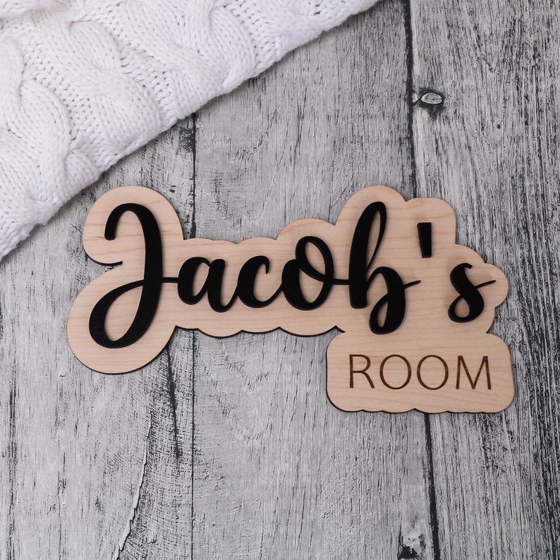 May include: Wooden sign with the text "Jacob's Room" in black lettering. The sign is made of light wood and has a rustic look.