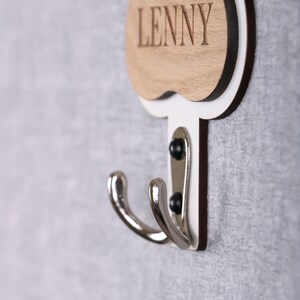 May include: A white wooden coat hook with a double hook and a wooden nameplate that says "LENNY".
